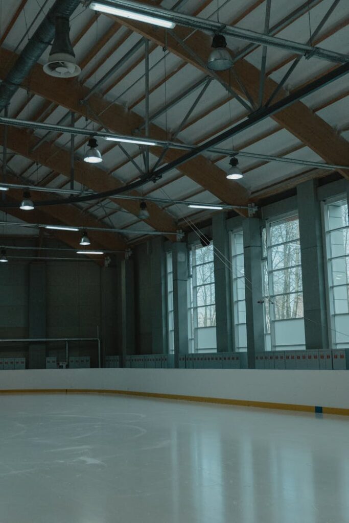 Spacious indoor ice skating rink with large windows and natural lighting.